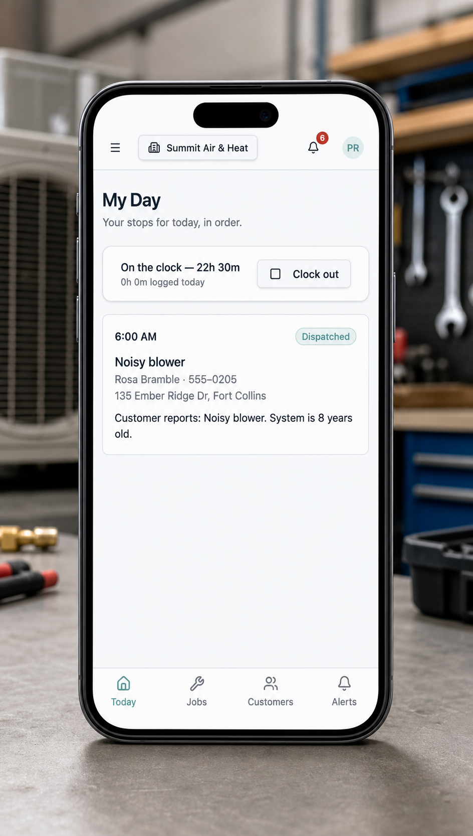 JobOpsPro My Day schedule shown on a phone in front of HVAC equipment